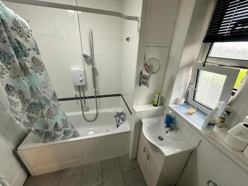 a bathroom with a shower and a tub and a sink at Aldgate East Rooms R2 in London