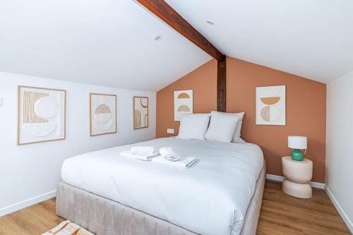 Un dormitorio con una gran cama blanca en una habitación. en Appartement lumineux à 5 minutes de la capitale, en Bagnolet
