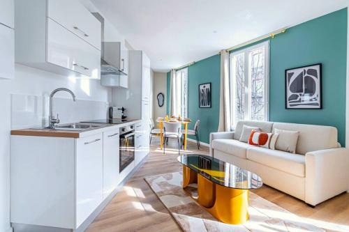 une cuisine et un salon avec un canapé et une table dans l'établissement Appartement lumineux à 5 minutes de la capitale, à Bagnolet