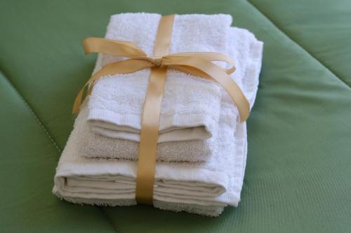 a stack of towels with a bow on a bed at Ama Casa Siracusa in Siracusa