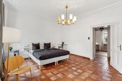 ein Schlafzimmer mit einem Bett, einem Tisch und einem Kronleuchter in der Unterkunft Wunderschönes 4 Zimmer Altbau Apartment mit Terrasse und Patio in Wuppertal