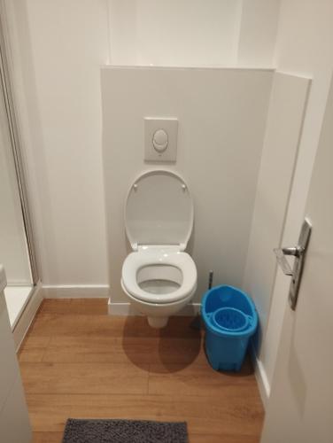 une petite salle de bains avec toilettes et seau bleu dans l'établissement Appart hotel, à Dijon