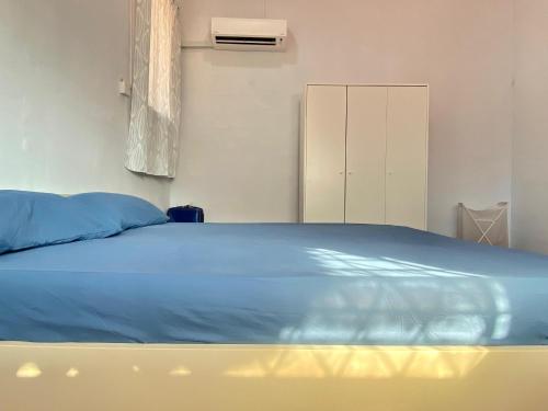 a bedroom with a bed with a blue comforter at Home Sweet Home in Kota Kinabalu