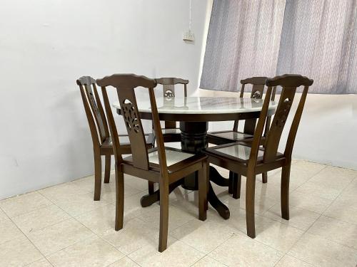 a dining room table with three chairs and a table and a table and chairsktop at Home Sweet Home in Kota Kinabalu