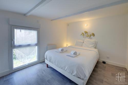 um quarto branco com uma cama grande e uma janela em HALTE 3 / GUÈS DE VEIGNE em Veigné