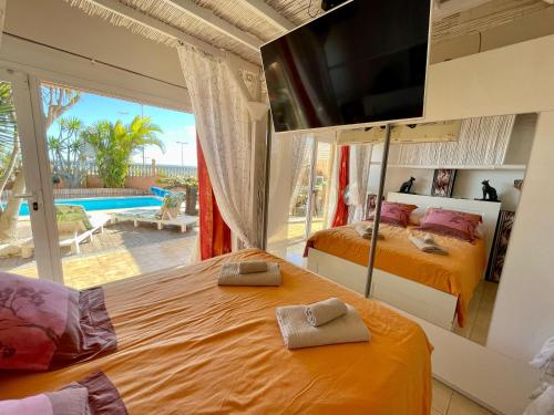 2 camas en un dormitorio con vistas a la piscina en Casa Zen Caleta de Fuste, en Caleta de Fuste