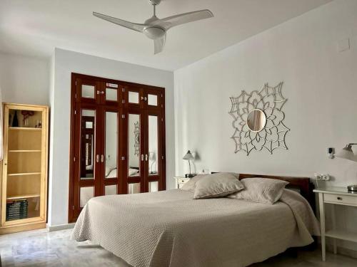 1 dormitorio blanco con 1 cama y ventilador de techo en Cozy Comfy, en Sevilla