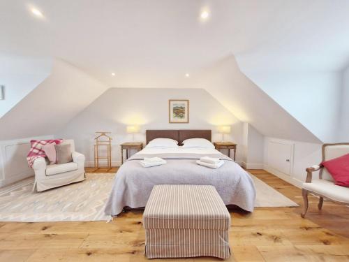 a bedroom with a large bed and two chairs at Castleton , Chichester in Chichester