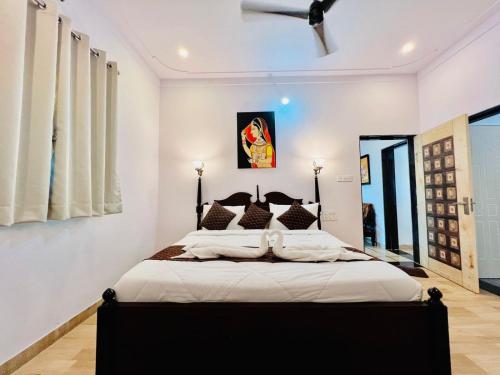 1 dormitorio con 1 cama grande y paredes blancas en The heavens villa, en Udaipur