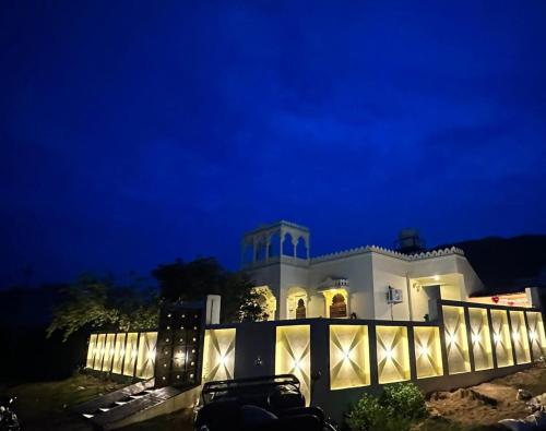 een groot wit huis 's nachts met verlichting bij The heavens villa in Udaipur