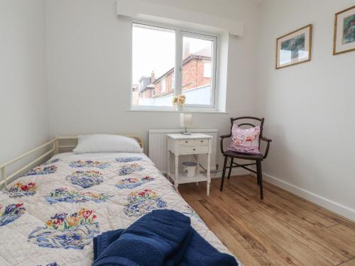 リザム・セント・アンズにある14 Berwick Roadのベッドルーム1室(ベッド1台、椅子、窓付)