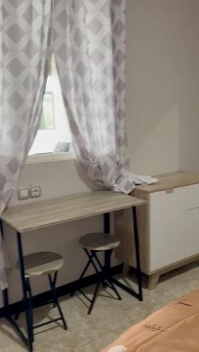 a desk with two stools in front of a window at AAA, Surya Indah, Pananjakan Bromo Villa, Managed by Triple A Tour, Additional Bromo Sunrise Jeep Tour and Airport Shuttle in Pasuruan