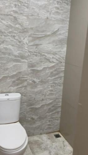 a bathroom with a toilet and a stone wall at AAA, Surya Indah, Pananjakan Bromo Villa, Managed by Triple A Tour, Additional Bromo Sunrise Jeep Tour and Airport Shuttle in Pasuruan