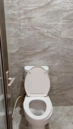 a bathroom with a white toilet in a stall at AAA, Surya Indah, Pananjakan Bromo Villa, Managed by Triple A Tour, Additional Bromo Sunrise Jeep Tour and Airport Shuttle in Pasuruan