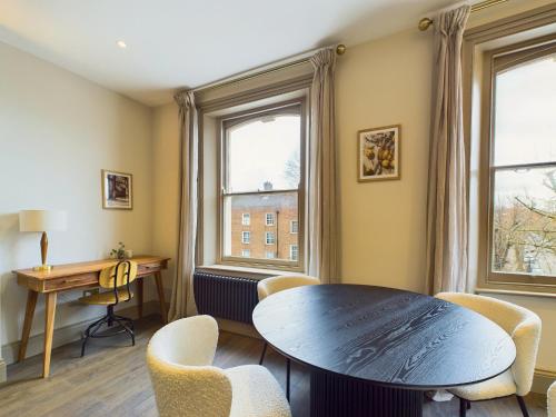 a living room with a table and chairs and a desk at Be London - The St John's Wood Residences in London