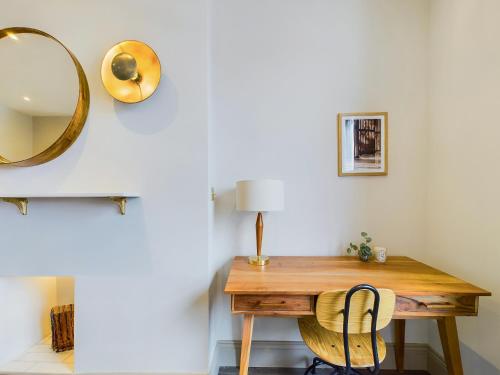 a desk in a room with a mirror and a chair at Be London - The St John's Wood Residences in London