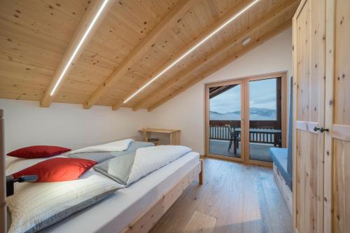 a bedroom with a bed and a large window at Parliflhof Apt Langfenn in Meltina