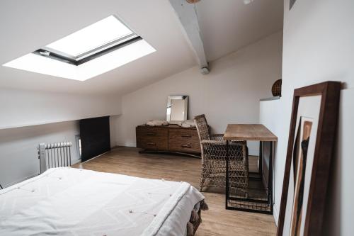 - une chambre avec un lit, un bureau et une lucarne dans l'établissement Terrasse tropezienne, à La Ciotat