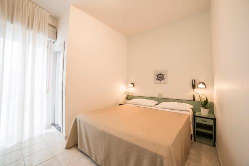 a bedroom with a bed and a window at Ambra Hotel Cattolica in Cattolica