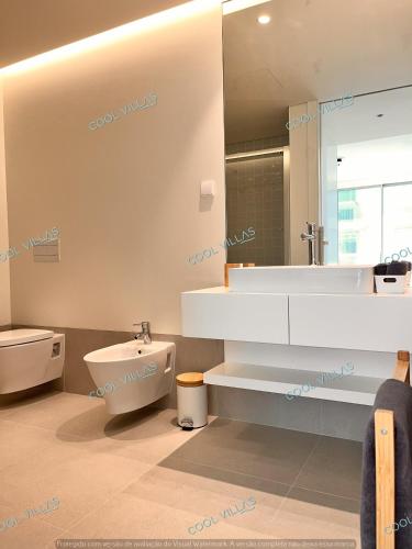 a bathroom with a toilet and a large mirror at BeachFront Apartment - 4 pax - swimming pool in Armação de Pêra
