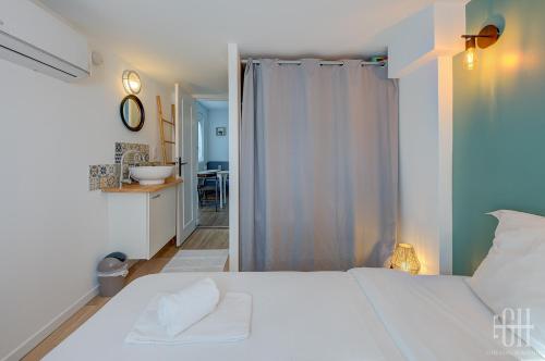 1 Schlafzimmer mit einem weißen Bett und einem Badezimmer in der Unterkunft La Halte 2 in Veigné