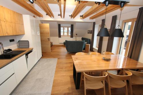 a kitchen and dining room with a wooden table and chairs at Helly - Kvilda - apartmány in Kvilda