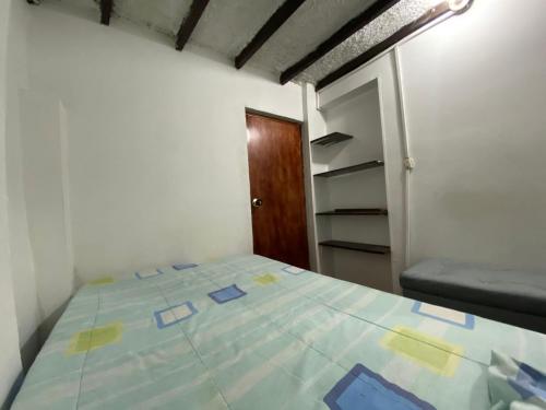 a bedroom with a bed with blue and yellow sheets at Habitación Manizales #2 in Manizales