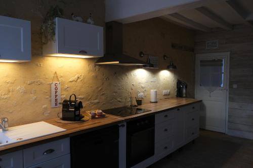 a kitchen with white cabinets and a counter top at Gite Le Cozy in Val-au-Perche