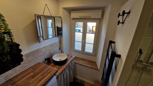 a bathroom with a sink and a window at Gite Le Cozy in Val-au-Perche