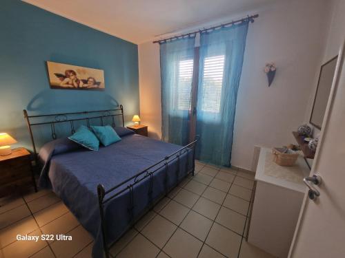 a bedroom with a bed and a blue wall at Appartamento Sabrina in San Vito lo Capo