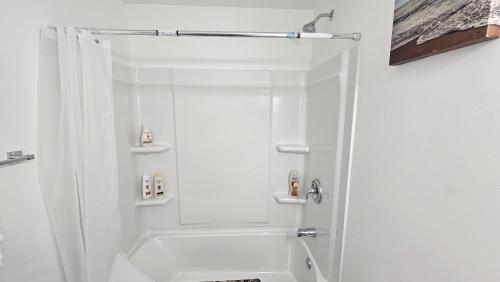 a white bathroom with a shower and a sink at New Decently Furnished Suit in Regina