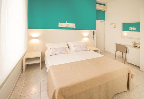 a bedroom with a large bed and a desk at Ambra Hotel Cattolica in Cattolica