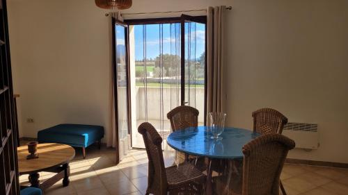 une salle à manger avec une table et des chaises et une fenêtre dans l'établissement PARADISU, à Biguglia