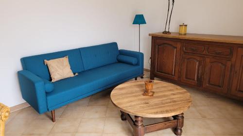 un canapé bleu dans un salon avec une table dans l'établissement PARADISU, à Biguglia