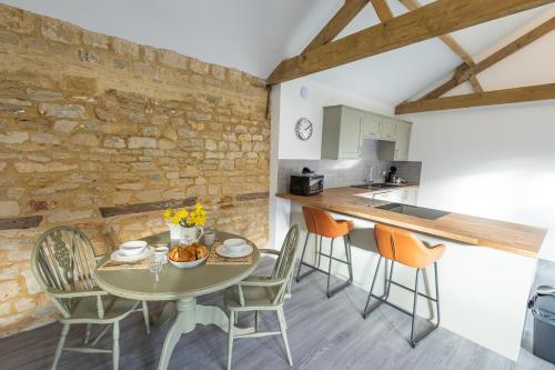 een keuken en eetkamer met een tafel en stoelen bij Hedgehogs Home at Tove Valley Cottages in Towcester