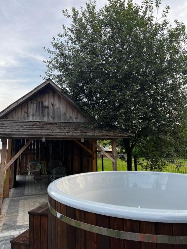 a bath tub in front of a building with a tree at Sielanka Roztocze in Pary