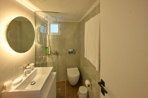 a bathroom with a sink and a toilet and a mirror at 2024 superior modern studio! in Mytilene