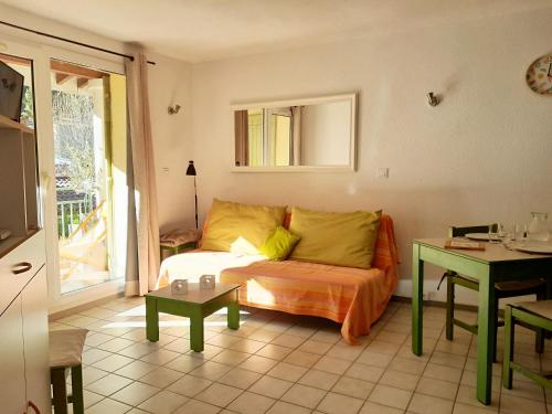 ein Wohnzimmer mit einem Bett und einem Tisch in der Unterkunft Le Dignois in Digne-les-Bains