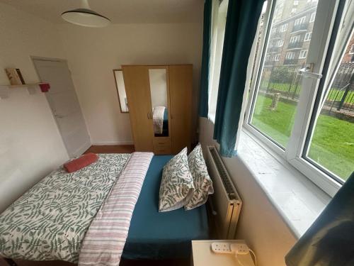 a small bedroom with a bed and a window at Shoreditch Rooms R1 in London