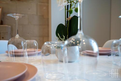 a table with wine glasses and plates and flowers at Le Grain De Folie / Place Des Halles in Tours