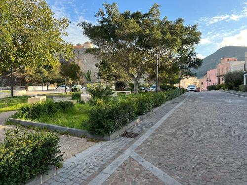 a cobblestone street in a city with trees and bushes at "Sweet Life" Casa Vacanze in Lipari