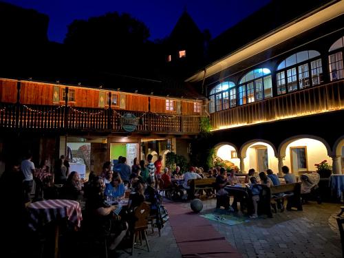 um grupo de pessoas sentadas em mesas fora de um edifício em Herr Berge Steirisch Ursprung em Brodingberg