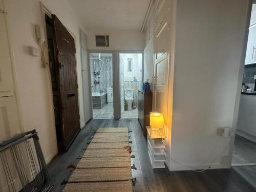 a hallway with a bathroom with a toilet and a rug at Shoreditch Rooms R2 in London