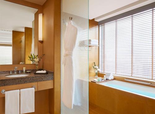 a bathroom with a tub and a sink and a window at Grand Hyatt Mumbai Hotel and Residences in Mumbai