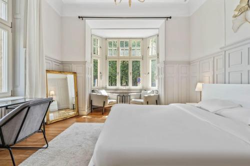 Dormitorio blanco con cama y ventana grande en Sleek and Sophisticated in Prime Location ID18, en Luxemburgo