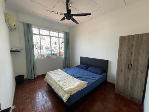 Peach Villa @ Putatan في كوتا كينابالو: غرفة نوم بسرير ومروحة سقف