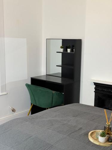 a bedroom with a black desk and a green chair at NEW Unique 4 Bed Families Contractors 靠近唐人街 in Nottingham