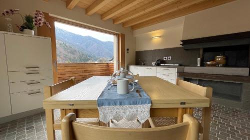 a kitchen with a wooden table with chairs and a window at Ledro Luxury Spa House in Ledro