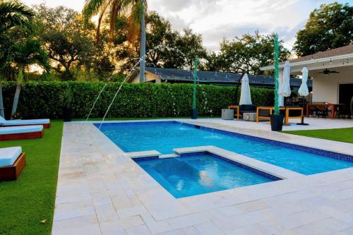- une piscine au milieu d'une cour dans l'établissement Modern & Bright Retreat by the Beach, Airport & Casino! Pool & Jacuzzi!, à Dania Beach