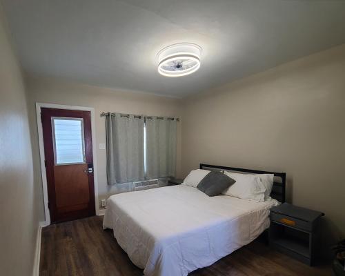 a bedroom with a white bed and a window at Hotel on Magnolia East 'HOME' in Wildwood